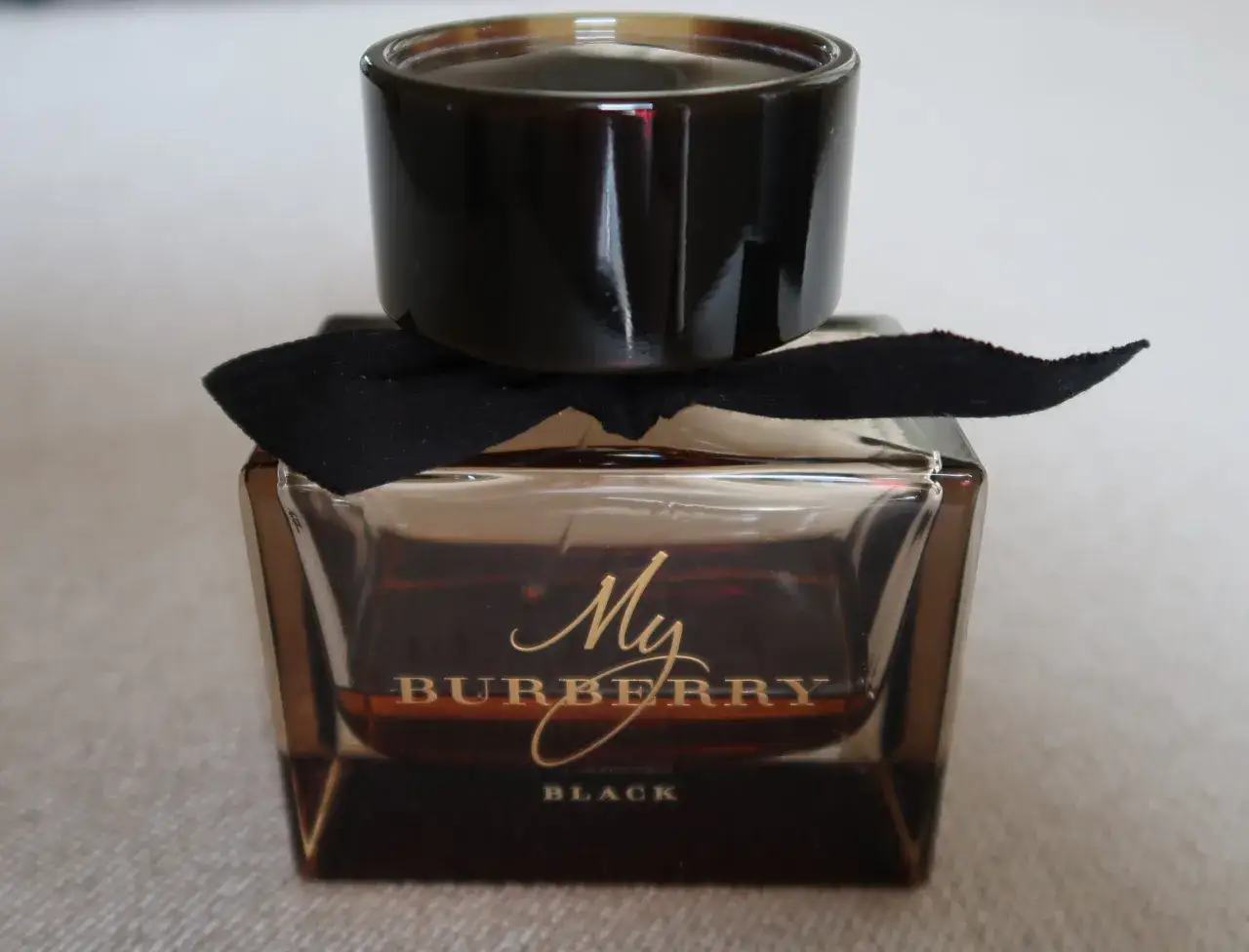 Elegancka buteleczka perfum My Burberry Black z czarną wstążką.