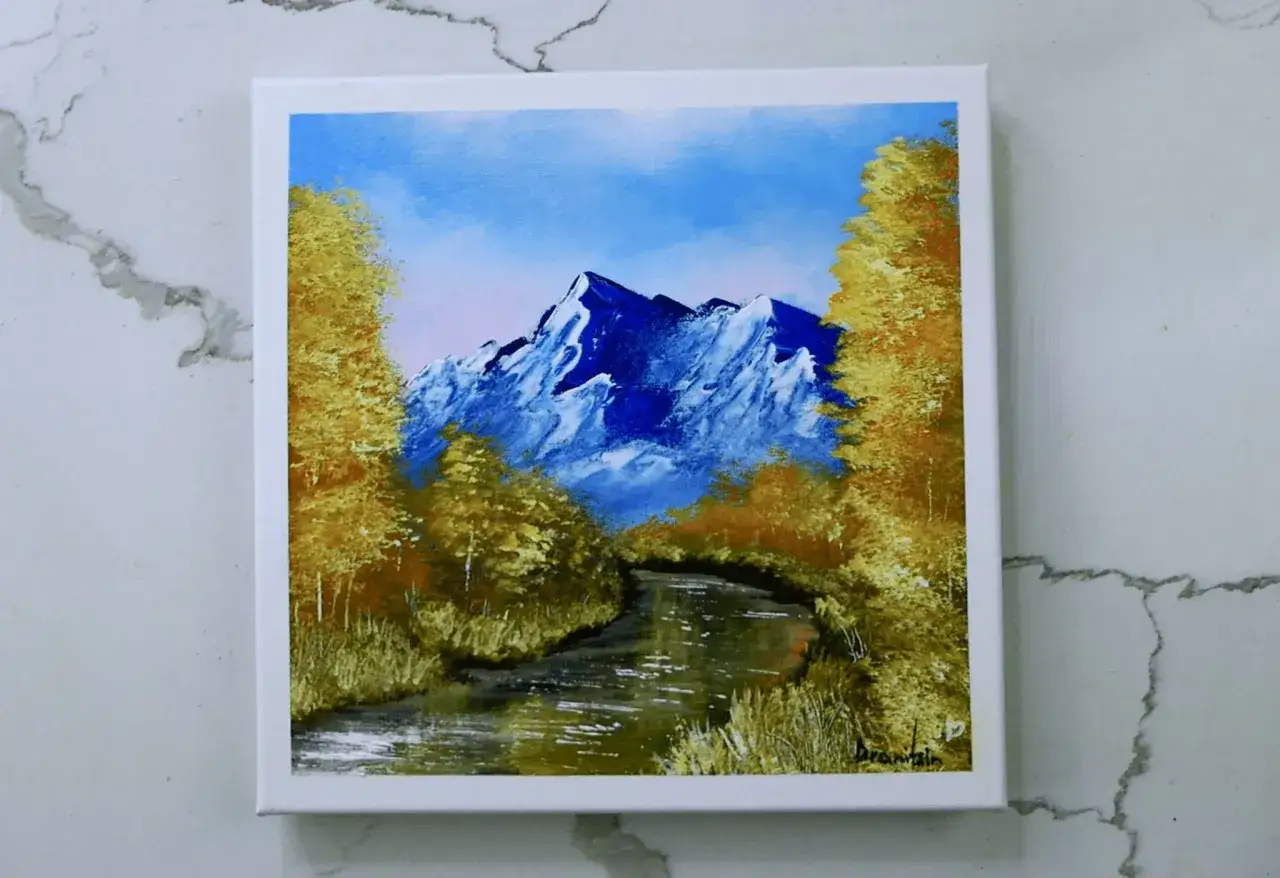 Une rivi&egrave;re serpente &agrave; travers des arbres dor&eacute;s menant &agrave; des montagnes bleues majestueuses. Les plus belles aquarelles de paysages captur&eacute;es sur toile.