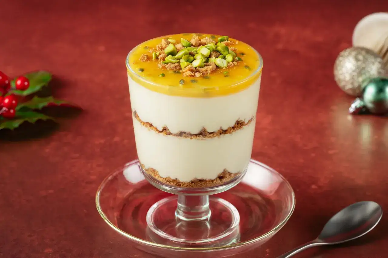Dessert cr&eacute;meux en verrine, superpos&eacute; de biscuits &eacute;miett&eacute;s et couronn&eacute; d'un coulis fruit de la passion vibrant, garni de pistaches.