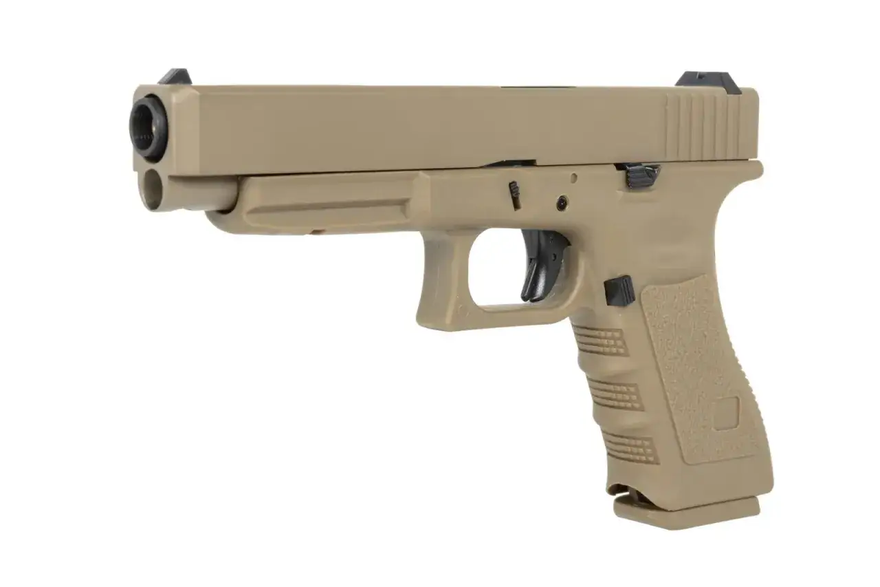 Beżowy pistolet ASG sprężynowy, gotowy do akcji na polu bitwy airsoftowej.