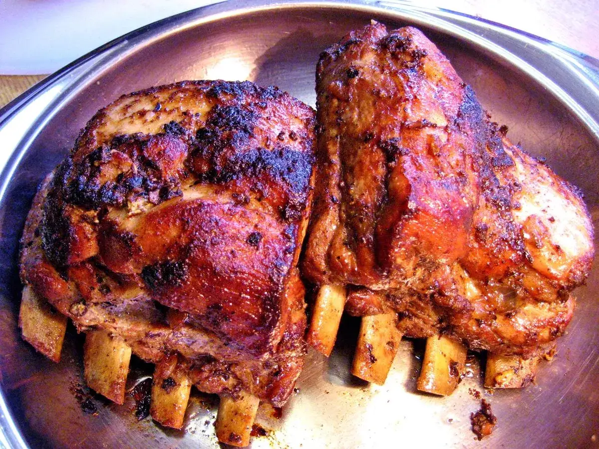 Zwei saftige, geschmorte Rippchen liegen in einer metallischen Schale. Sie sind goldbraun gebraten und duften verführerisch.