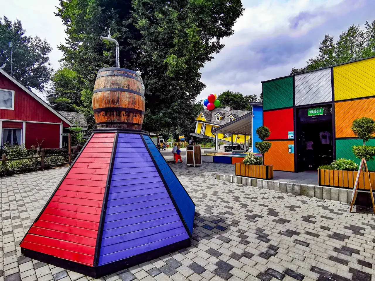 Kolorowe budynki i instalacje, jak beczka z kranem, tworzą magiczną atmosferę. Farma Iluzji Opole to świetne atrakcje dla dzieci, pełne zabawy i niezwykłych widoków.