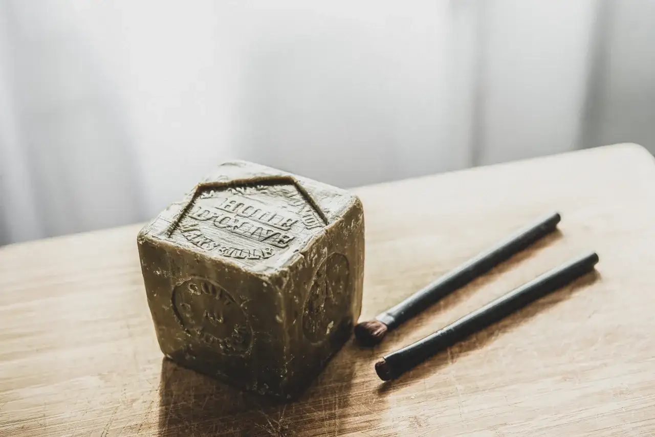 Un cube de savon de Marseille et deux pinceaux de maquillage, pr&ecirc;ts pour un nettoyage en profondeur.