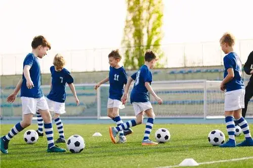 dzieci grające w piłkę nożną trening