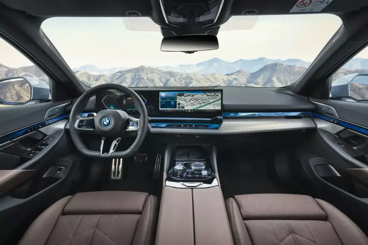 Wnętrze BMW 5 2025 z nowoczesnym ekranem multimedialnym i komfortowymi fotelami.