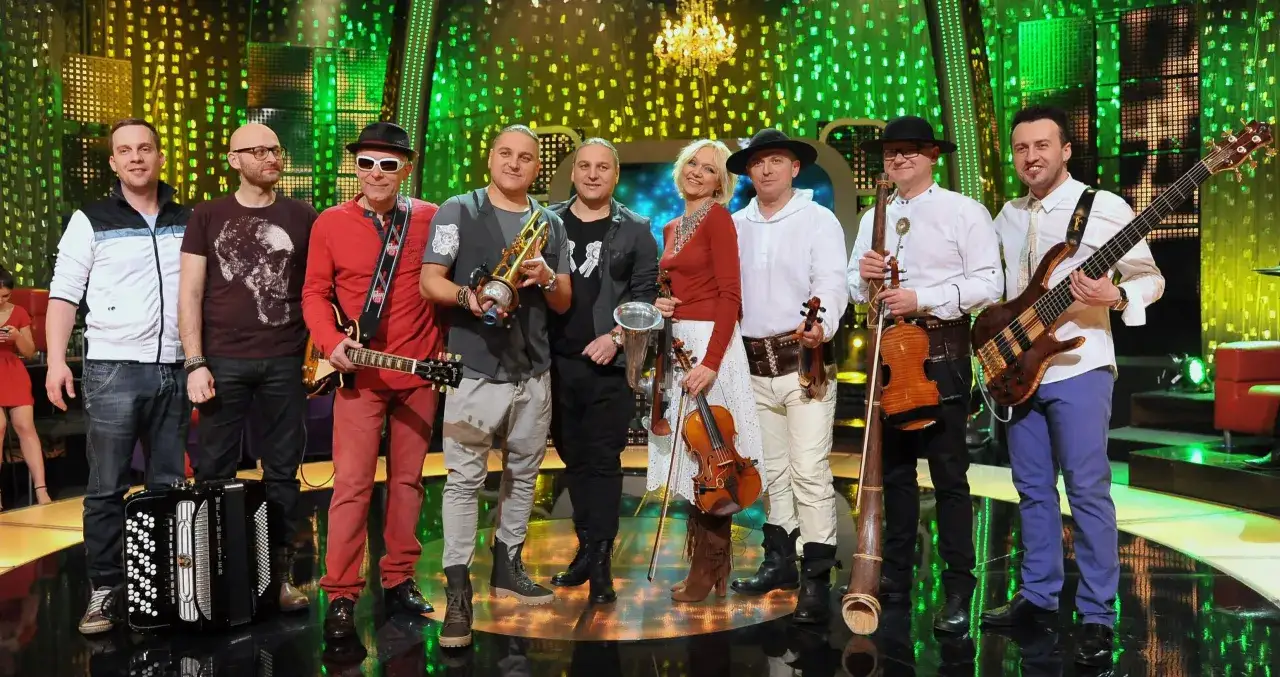 Zespół muzyczny w strojach ludowych i nowoczesnych, grający na instrumentach, kto śpiewa w Jaka to melodia.