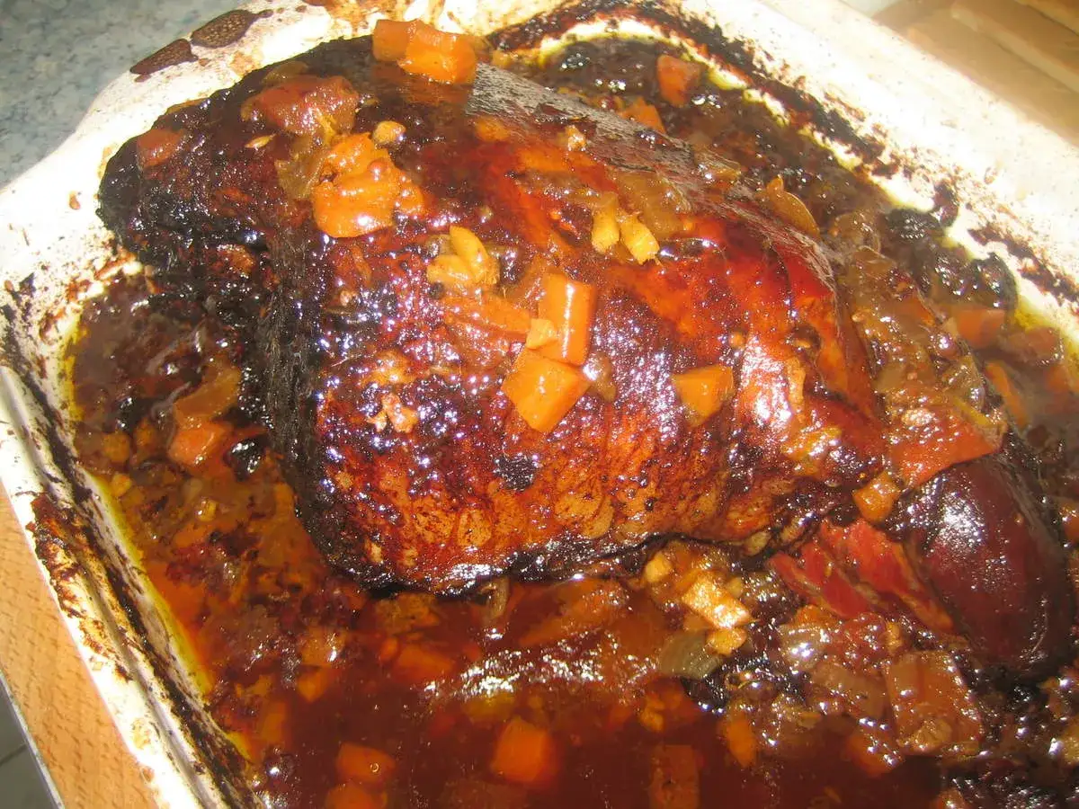 Gigot d'agneau r&ocirc;ti, napp&eacute; d'une sauce brune aux carottes et oignons, parfait accompagnement gigot d'agneau pour No&euml;l.