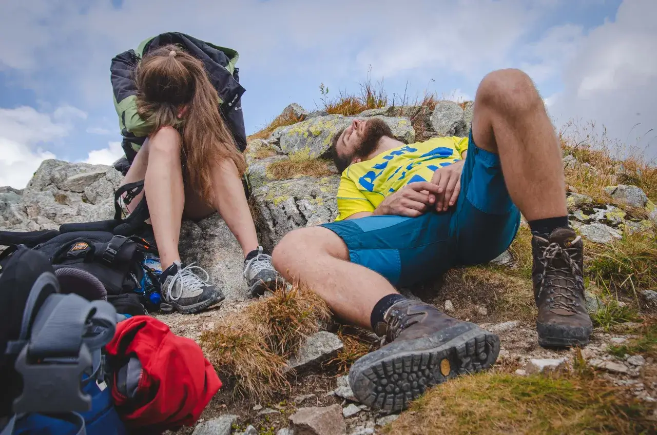 turysta w górach z plecakiem i butami trekkingowymi