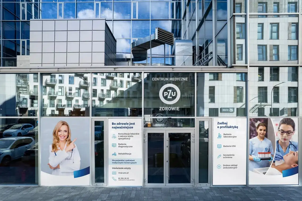 Nowoczesne centrum medyczne PZU Zdrowie z reklamami usług medycznych i zdjęciami personelu.