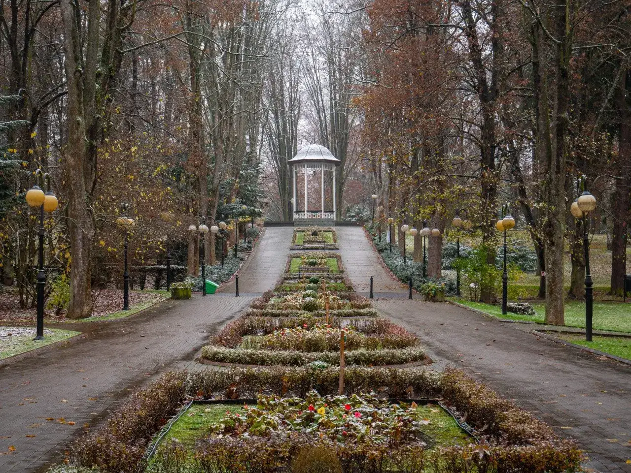 Alejka w parku, ozdobiona klombami i latarniami, prowadzi do altany. To jedna z urokliwych polanica zdr&oacute;j atrakcje.