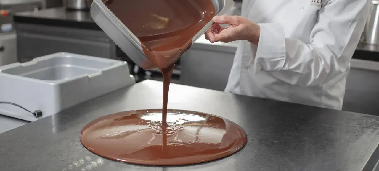 Un chef verse du chocolat fondu. mycryo c'est quoi ? C'est peut-être la technique pour obtenir cette texture parfaite.