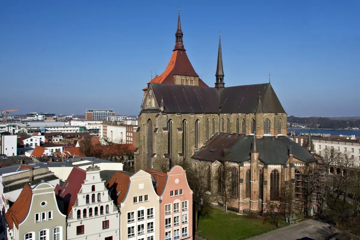 Blick über die Dächer der **Rostock Innenstadt** mit der Marienkirche und bunten Giebelhäusern.