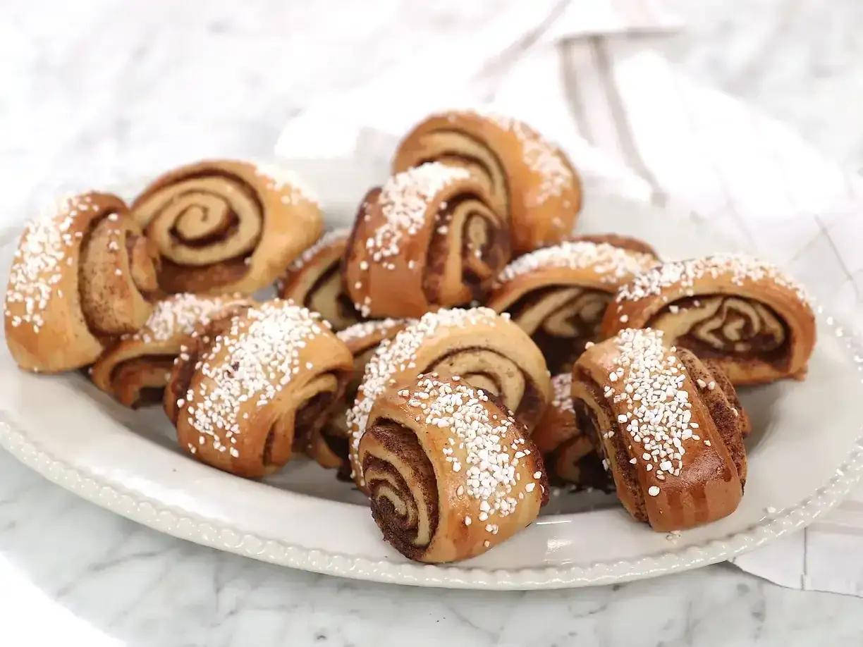 En tallrik med nybakade gifflar, perfekta för fikat. Dessa kanelbullar ser ut som ett underbart gifflar recept.