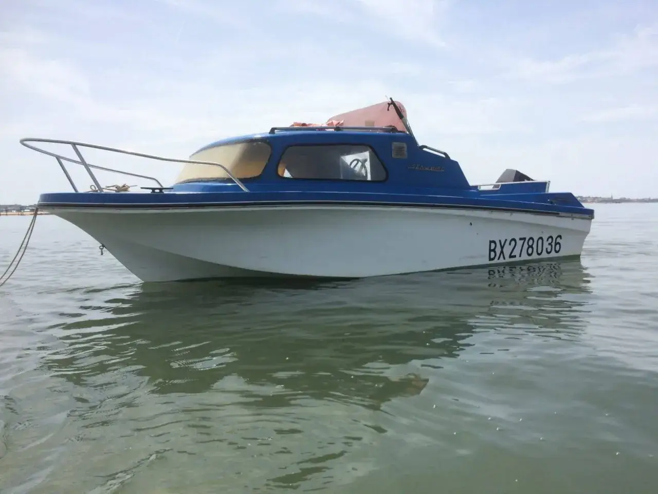 Bateau Jeanneau Sea Bird, immatriculé BX278036, à quai par temps calme.