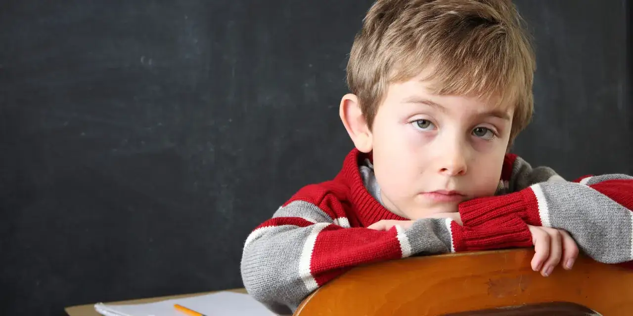 Bambino con sguardo pensieroso, forse riflette sui sintomi dell'iperattività.