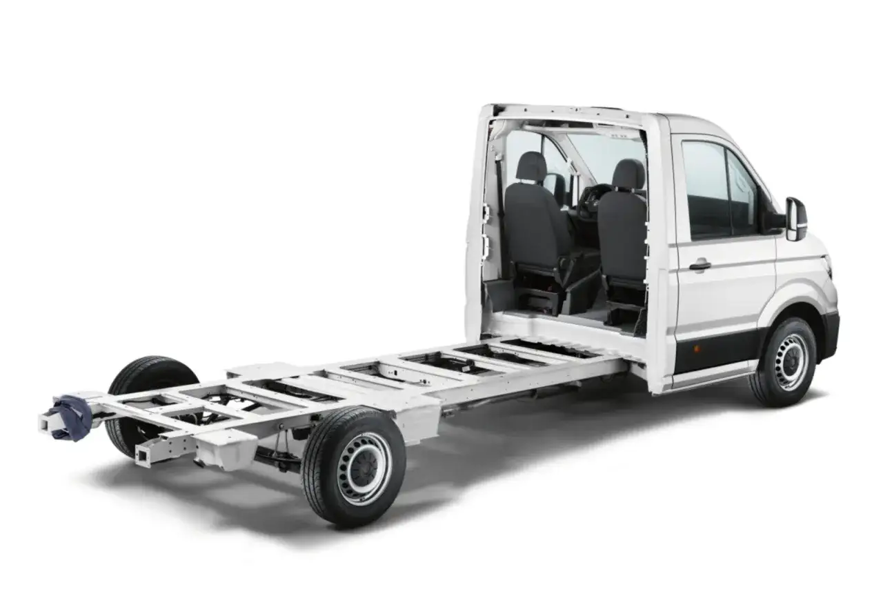 Podwozie białego Craftera VW z kabiną i dwoma siedzeniami, gotowe do zabudowy.