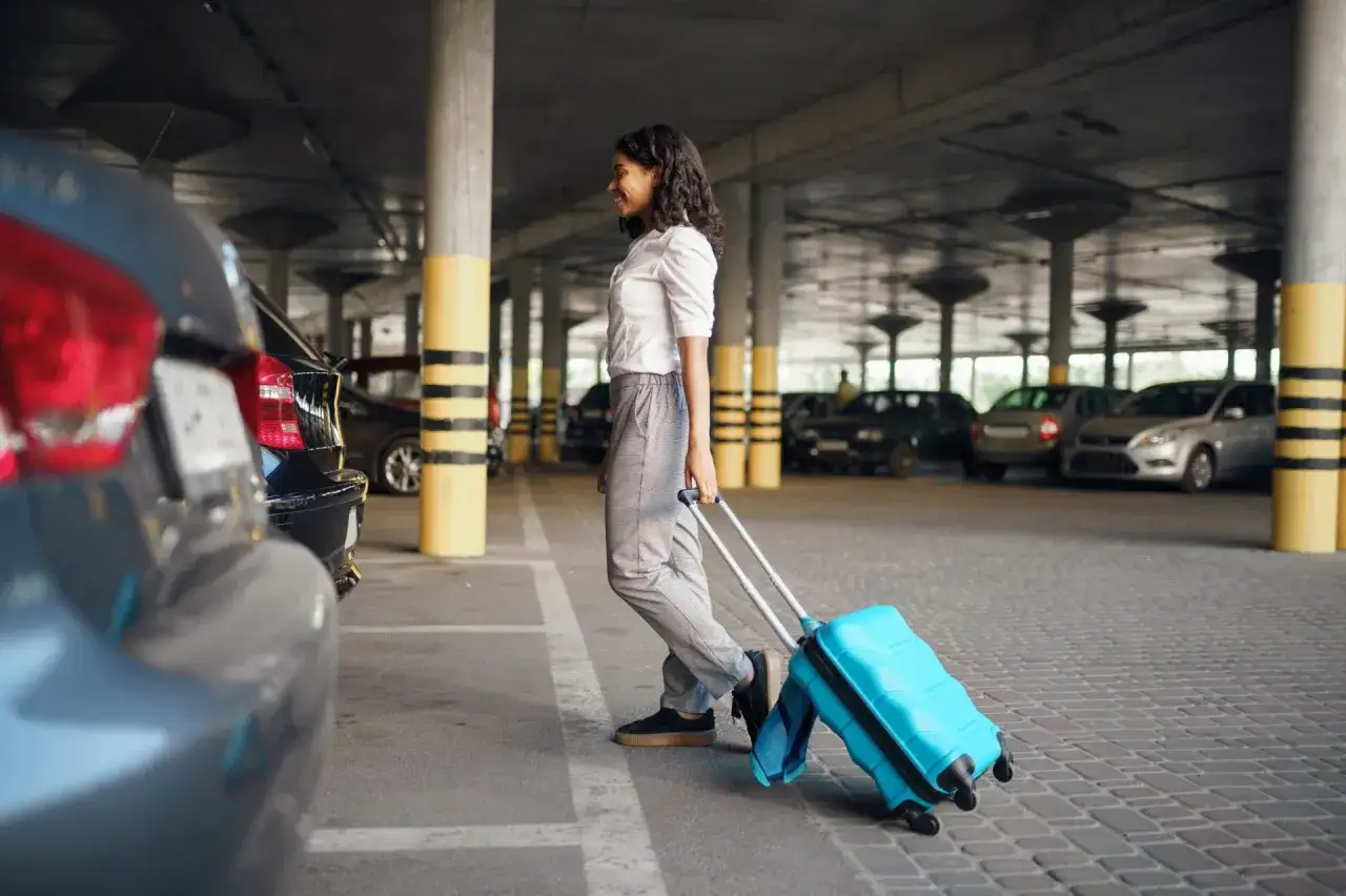 Frau mit Koffer im Parkhaus, bereit für den Valet Service.
