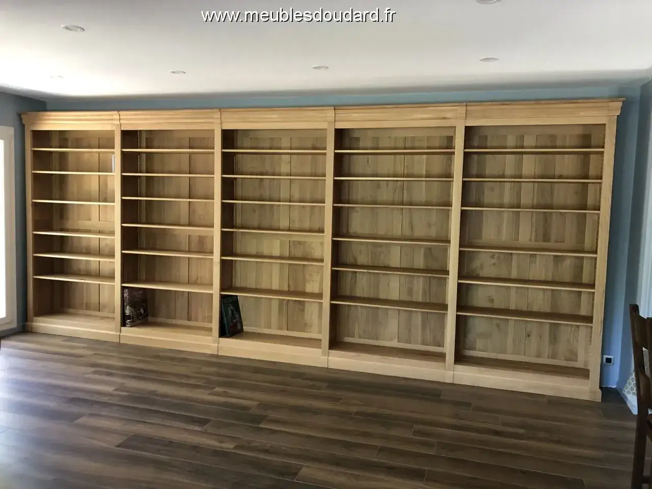Immense bibliothèque en bois clair, parfaite pour un projet diy. Elle est composée de plusieurs étagères vides, prêtes à accueillir vos livres.