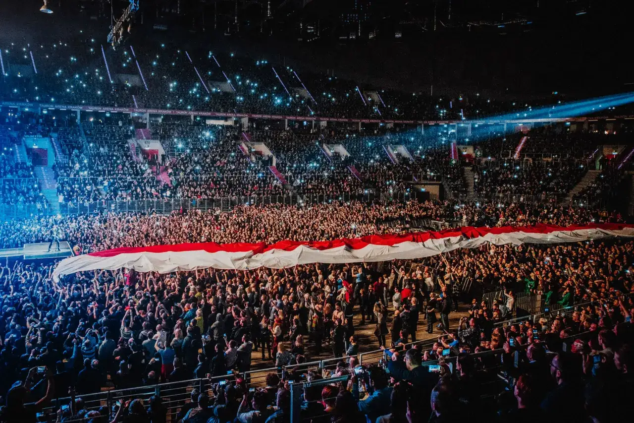 Tłum na koncercie Scorpions w Krakowie unosi biało-czerwoną flagę.