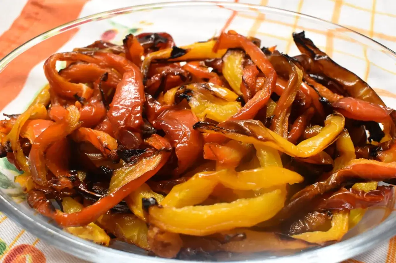 Peperoni rossi e gialli arrostiti in friggitrice ad aria, dolci e leggermente caramellati, pronti per essere gustati.