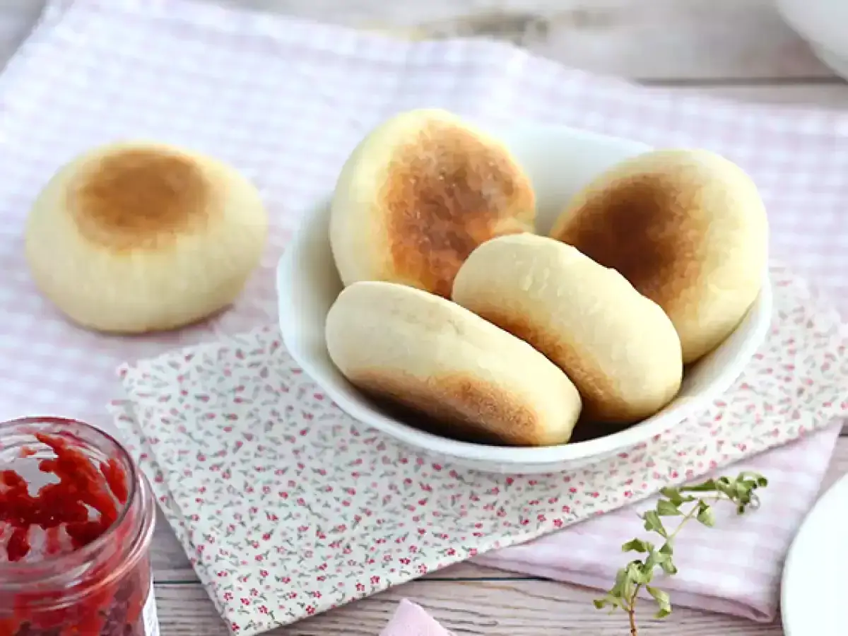 F&auml;rska, gyllene english muffins i en sk&aring;l, redo att avnjutas med sylt.