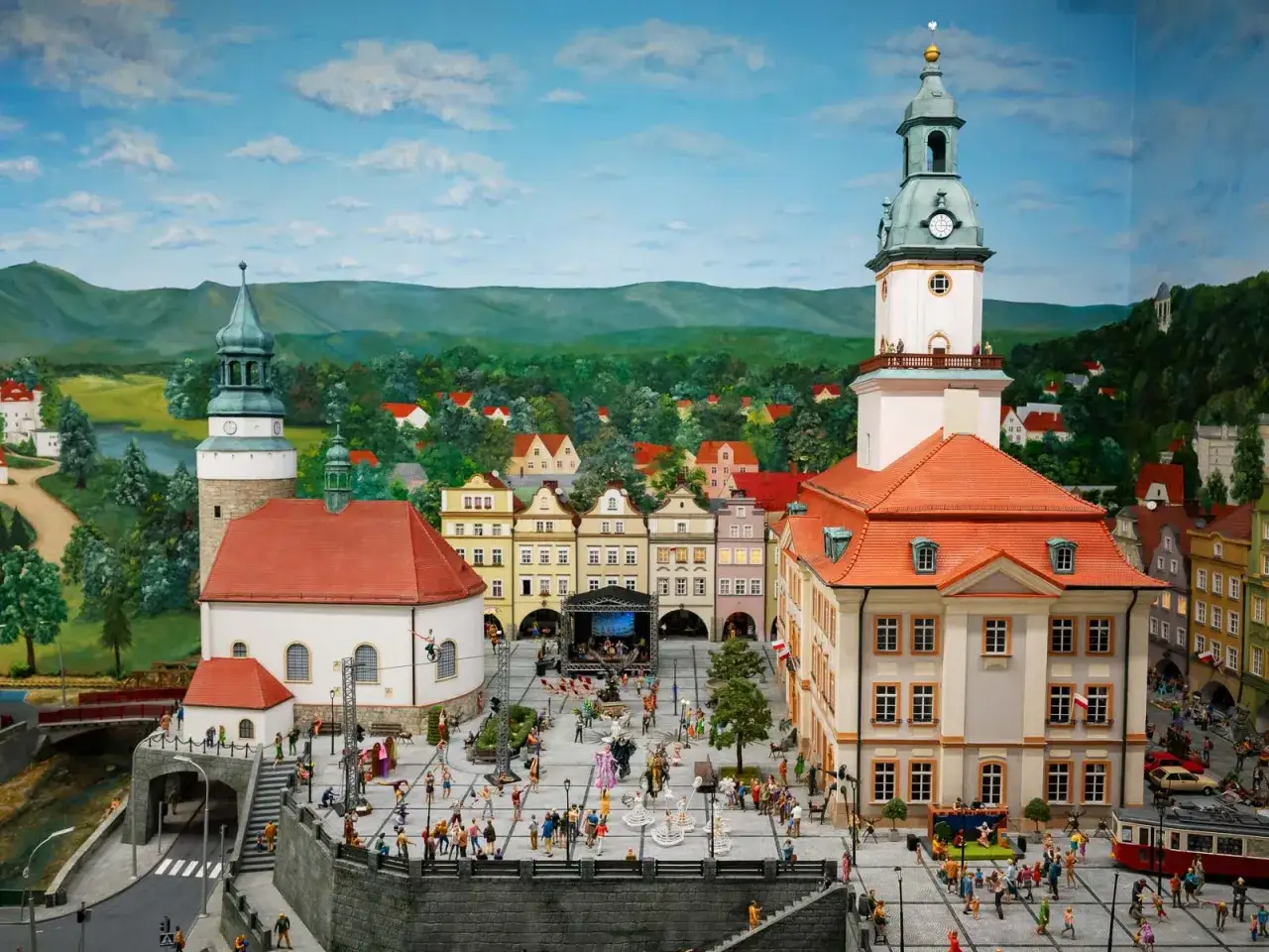 Miniaturowy rynek w Jeleniej G&oacute;rze, z wieżą ratuszową, kamieniczkami i tłumem ludzi.