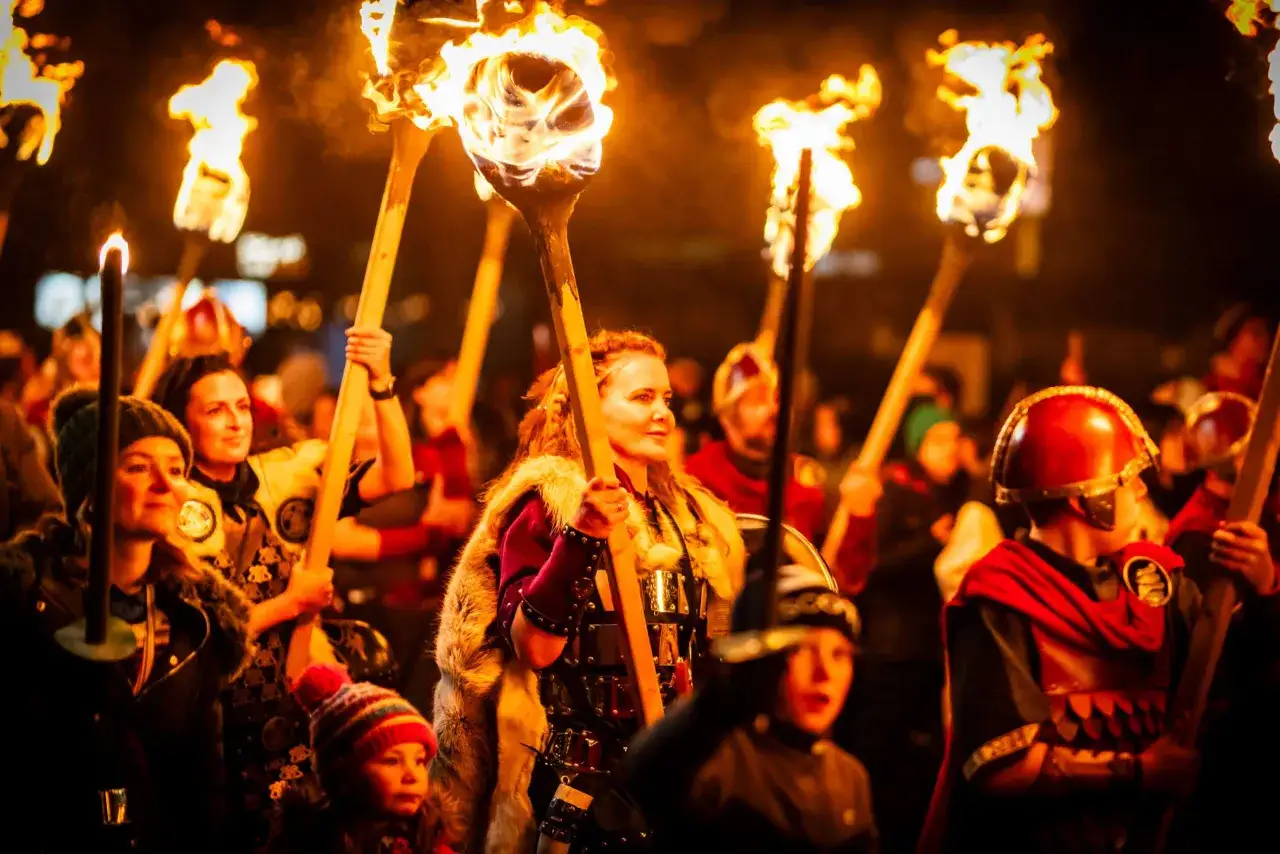 Uczestnicy parady z pochodniami, w historycznych strojach, celebrują święta w Wielkiej Brytanii.