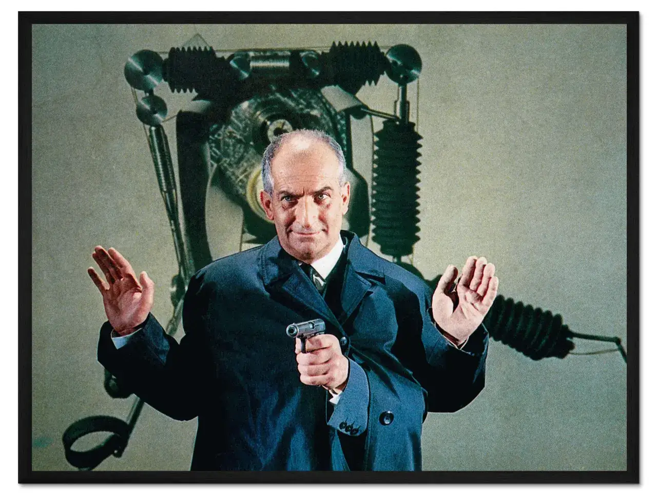 Louis de Funès w filmach, z pistoletem w dłoni i miną pełną grozy, na tle dziwacznej maszyny.