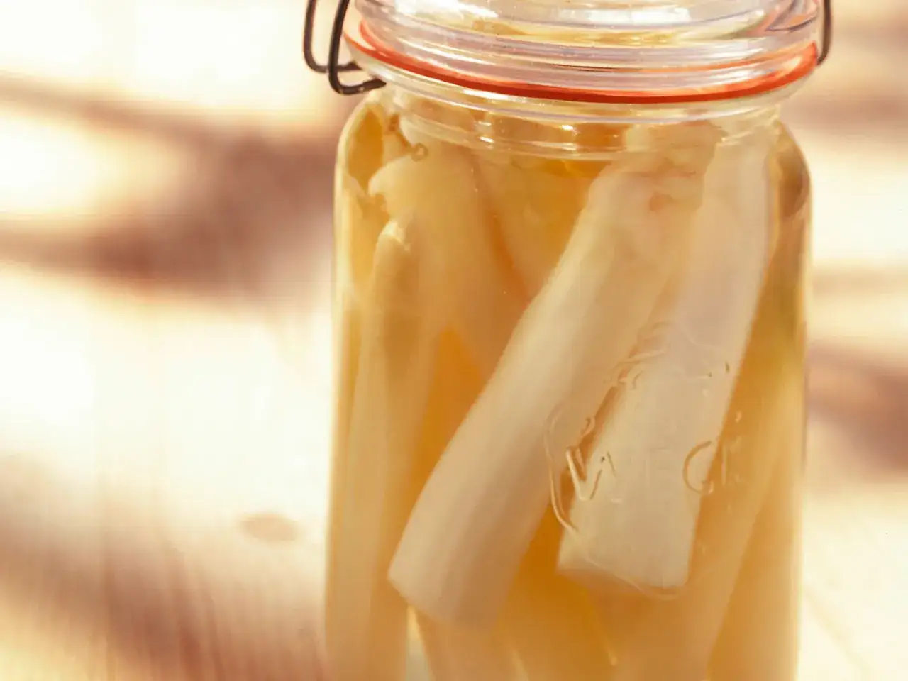 Ein Glas mit eingelegtem Spargel, bereit zum Einkochen. Der Spargel liegt in einer hellen Flüssigkeit.