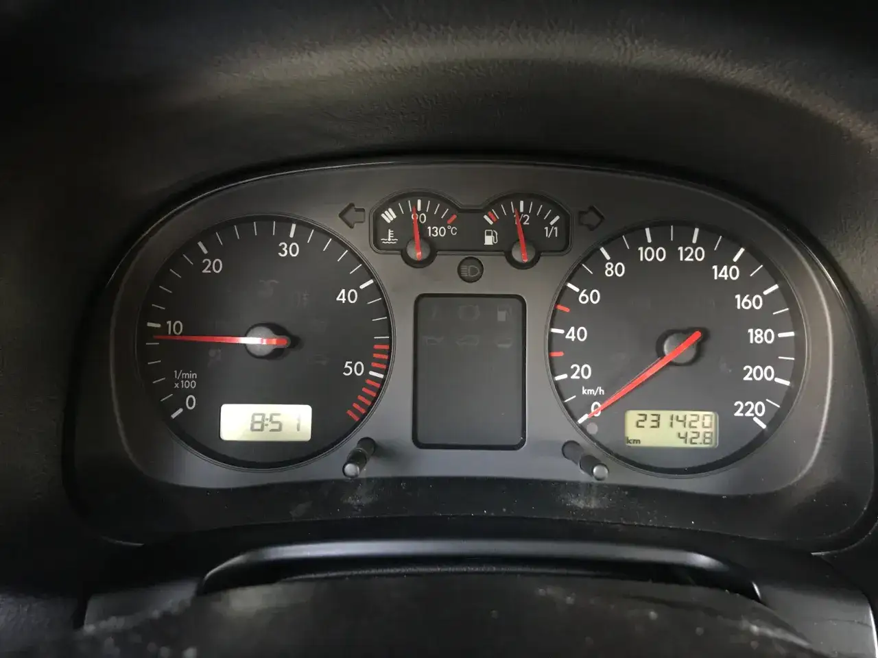 Deska rozdzielcza samochodu z widocznym licznikiem przebiegu 231420 km i wskaźnikiem paliwa. Korekta przebiegu po wymianie licznika.