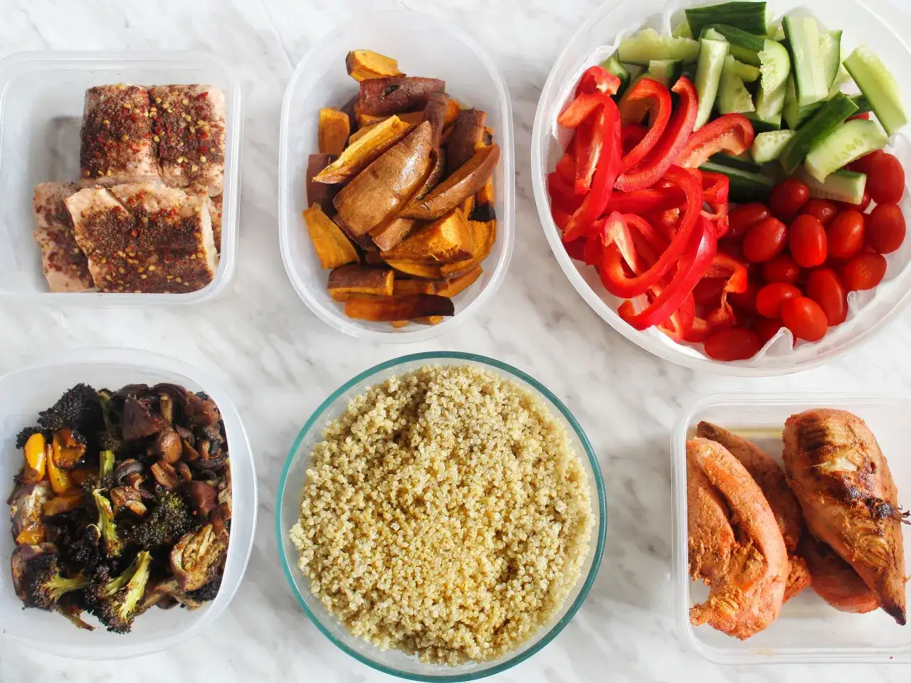 Préparation d'un menu diététique semaine : saumon épicé, patates douces rôties, quinoa, légumes variés et poulet.