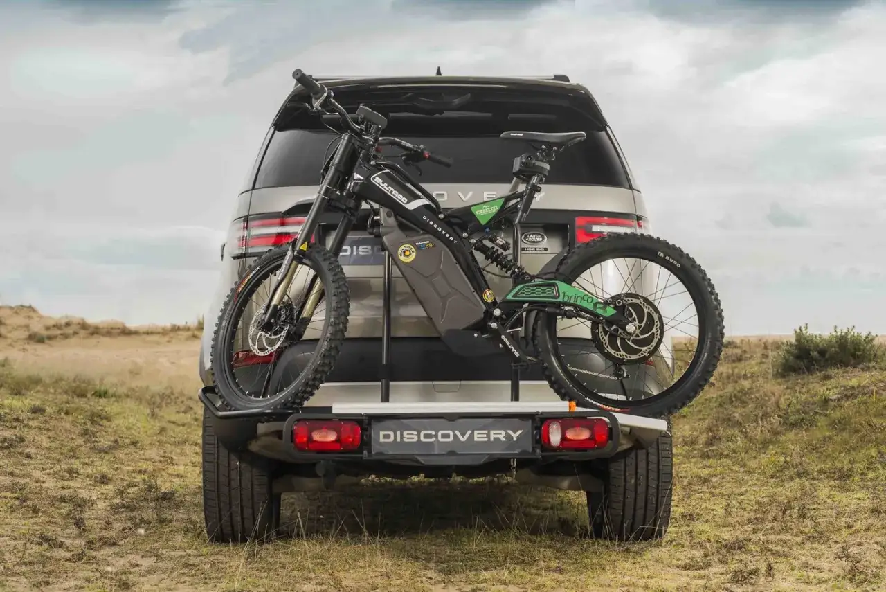 Bultaco Brinco, una bicicleta el&eacute;ctrica de monta&ntilde;a, montada en la parte trasera de un Land Rover Discovery, lista para la aventura.