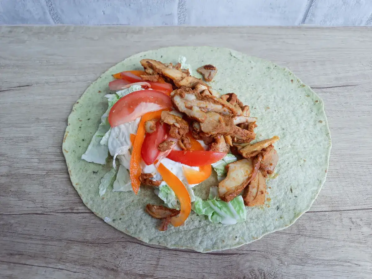 Pyszny kebab w tortilli z kurczakiem, warzywami i sosem. Idealny na szybki posiłek.