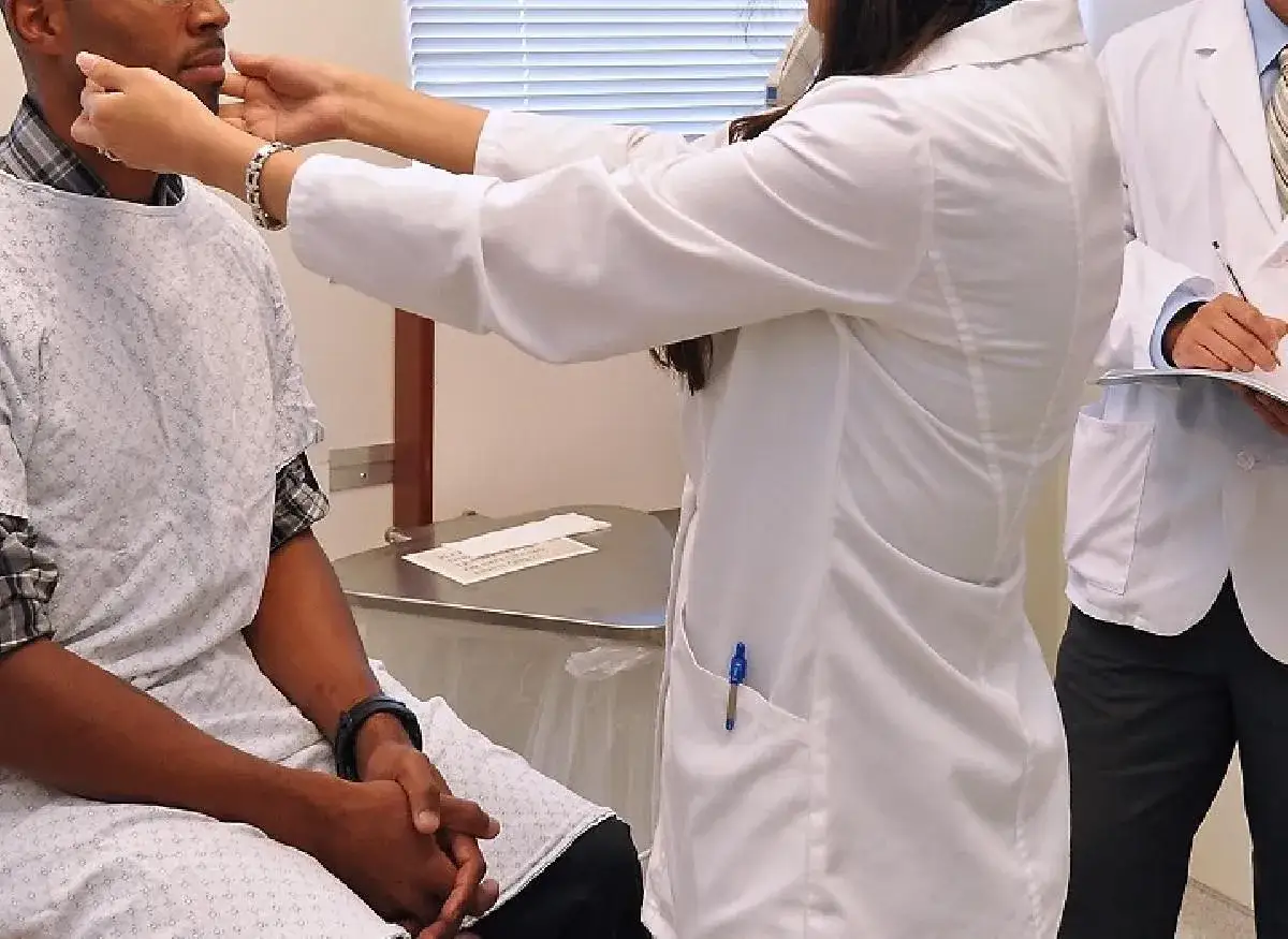 Medico esamina un paziente. Un altro medico prende appunti. Assistenza sanitaria per stranieri senza permesso di soggiorno.