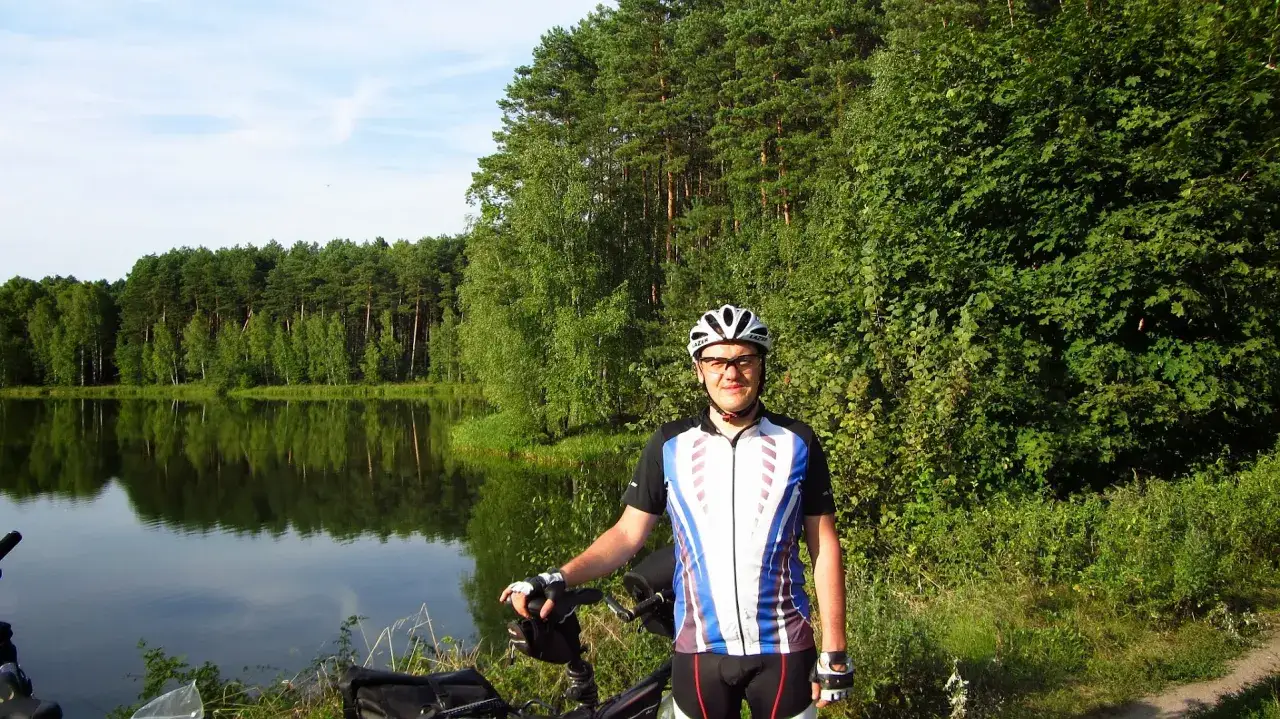 Rowerzysta na tle jeziora i lasu, piękny dzień na nadwarciańskim szlaku rowerowym.