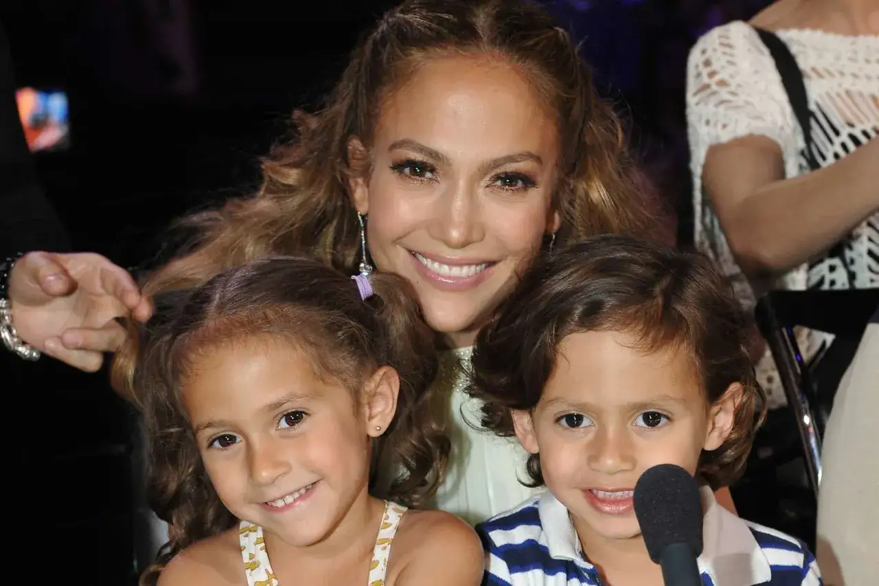 Jennifer Lopez z uśmiechem obejmuje swoje dzieci.