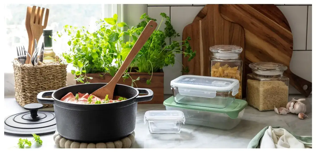 K&ouml;kets f&ouml;rberedelser: gryta med mat, f&auml;rska &ouml;rter, glasburkar med pasta och ris, samt matl&aring;dor f&ouml;r att frysa in mat.