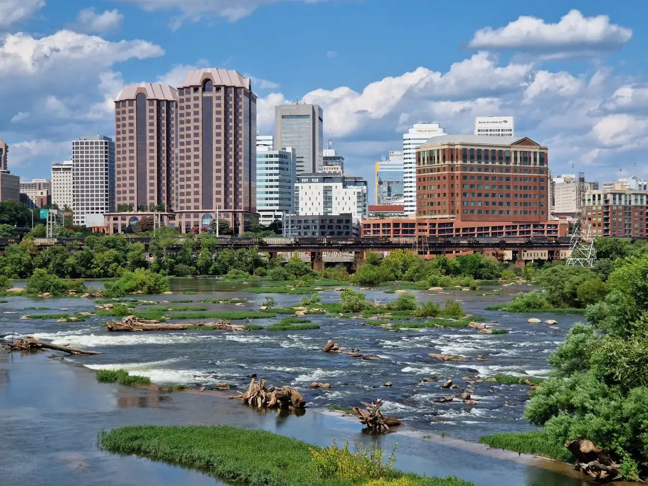 A scenic view of the James River rapids with the Richmond, VA skyline in the background, perfect for a weekend getaway.