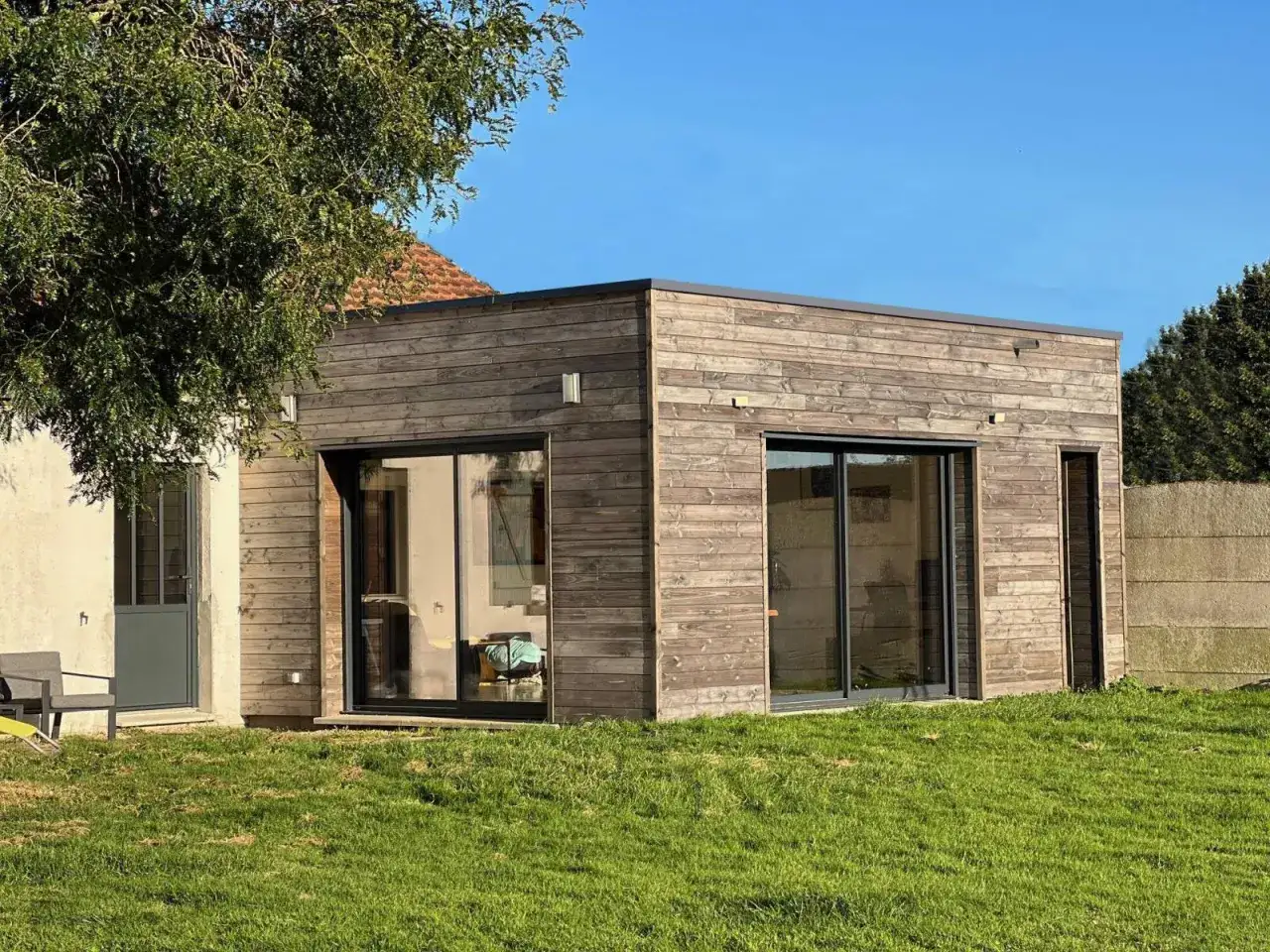 Extension moderne en bois avec grandes baies vitr&eacute;es, un projet de plan extension maison 20m2.