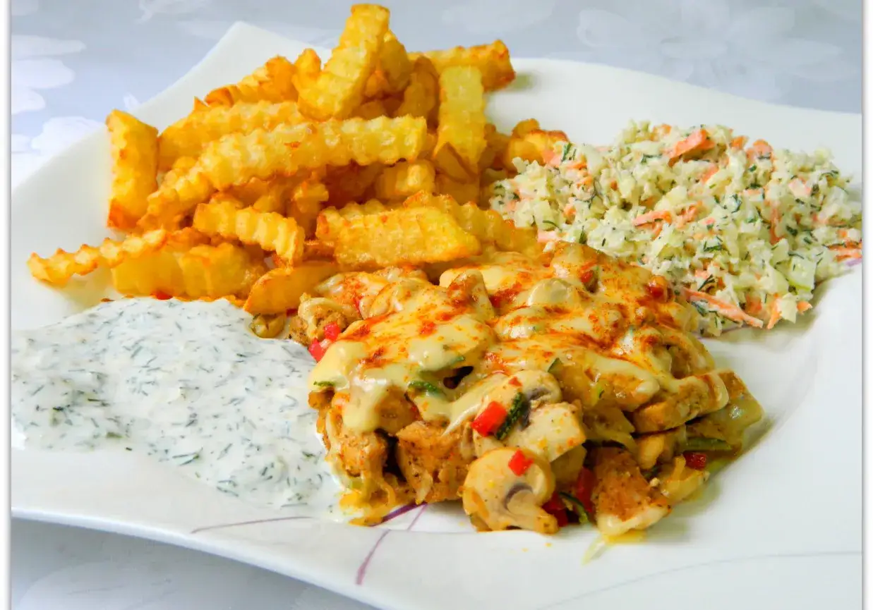 Pyszna shoarma drobiowa z serem, chrupiącymi frytkami, surówką i sosem czosnkowym na białym talerzu.