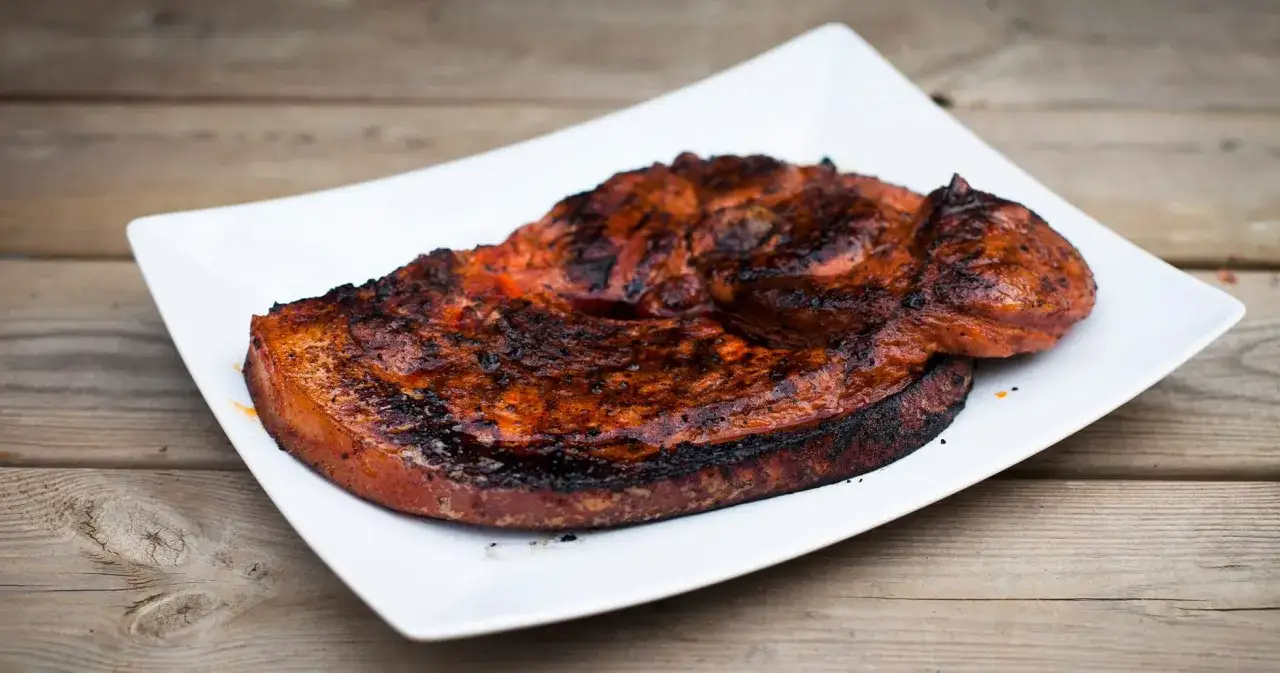 En perfekt grillad flintastek p&aring; en vit tallrik, redo att avnjutas.