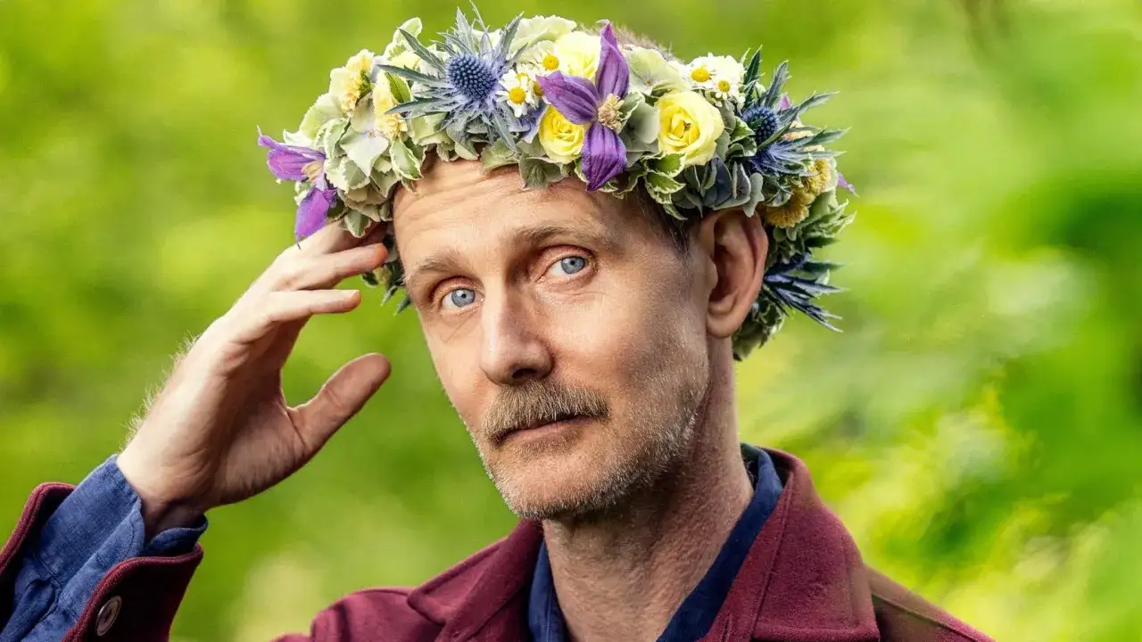 Man med blomsterkrans på huvudet, en sommarprat recension i blickfånget.