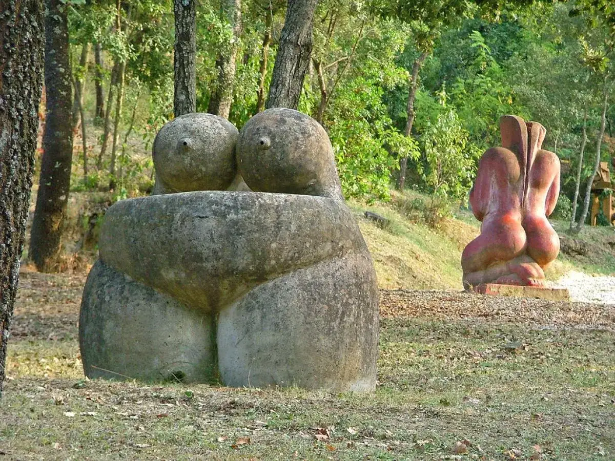 Esculturas de piedra en un bosque, evocando formas humanas en un museo de esculturas eróticas.