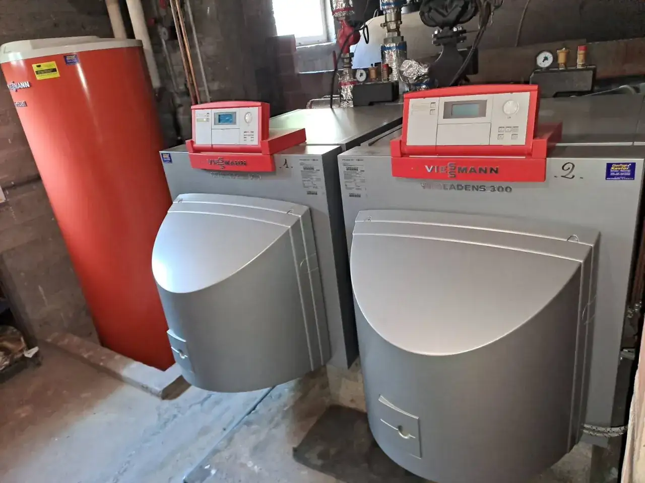 Deux chaudières Viessmann Vitoladens 300 avec un ballon d'eau chaude rouge. Idéal pour connaître le tarif entretien pompe à chaleur Atlantic.
