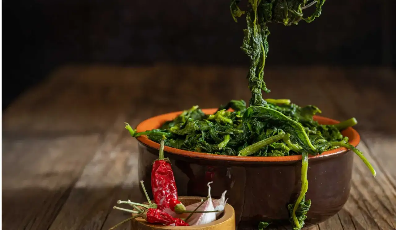 Un piatto di friarielli cotti, con peperoncino e aglio, pronti per essere gustati. Il periodo friarielli è un momento di sapori autentici.