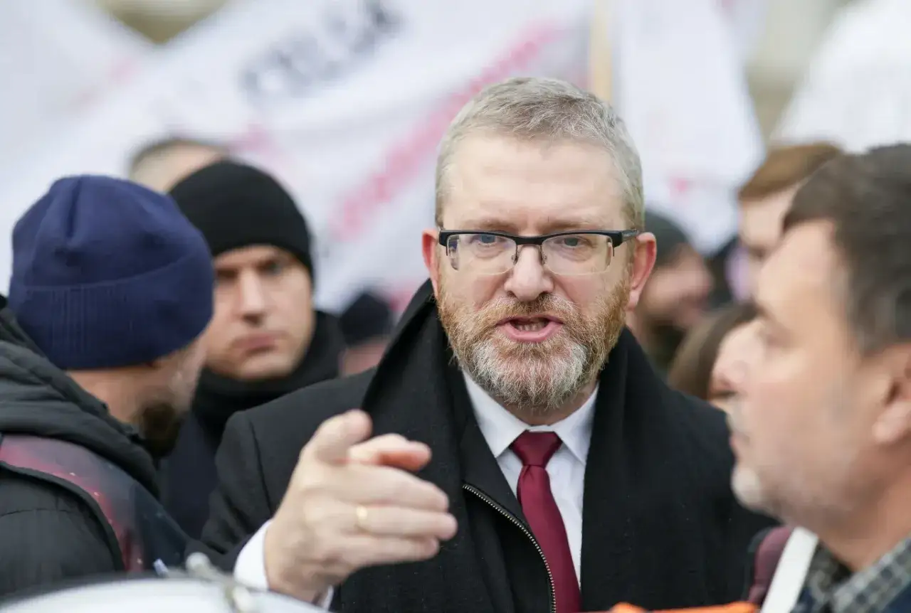 Mężczyzna w okularach i krawacie gestykuluje, dyskutując, czy wewnątrz Konfederacji dojdzie do rozłamu przed majowymi wyborami prezydenckimi.