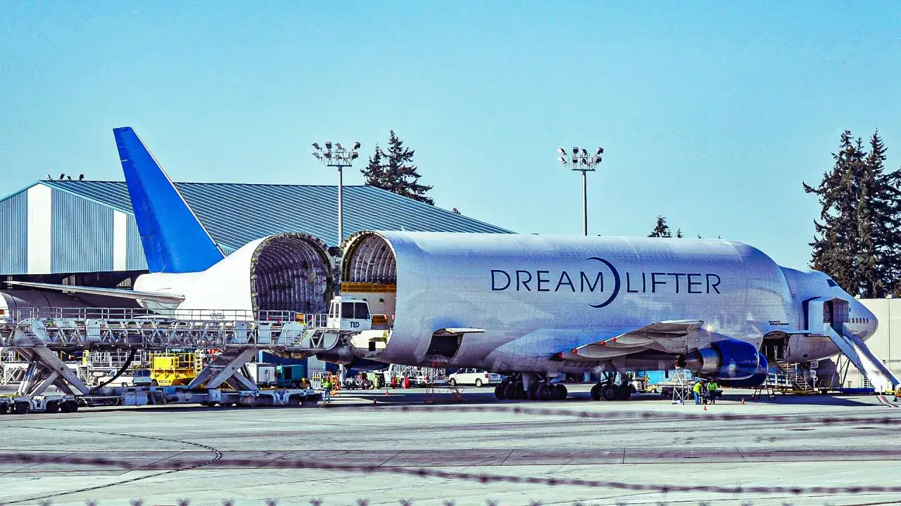 Der Boeing 747 Dreamlifter mit geöffnetem Rumpf steht auf dem Rollfeld, bereit für den Transport von Flugzeugteilen.