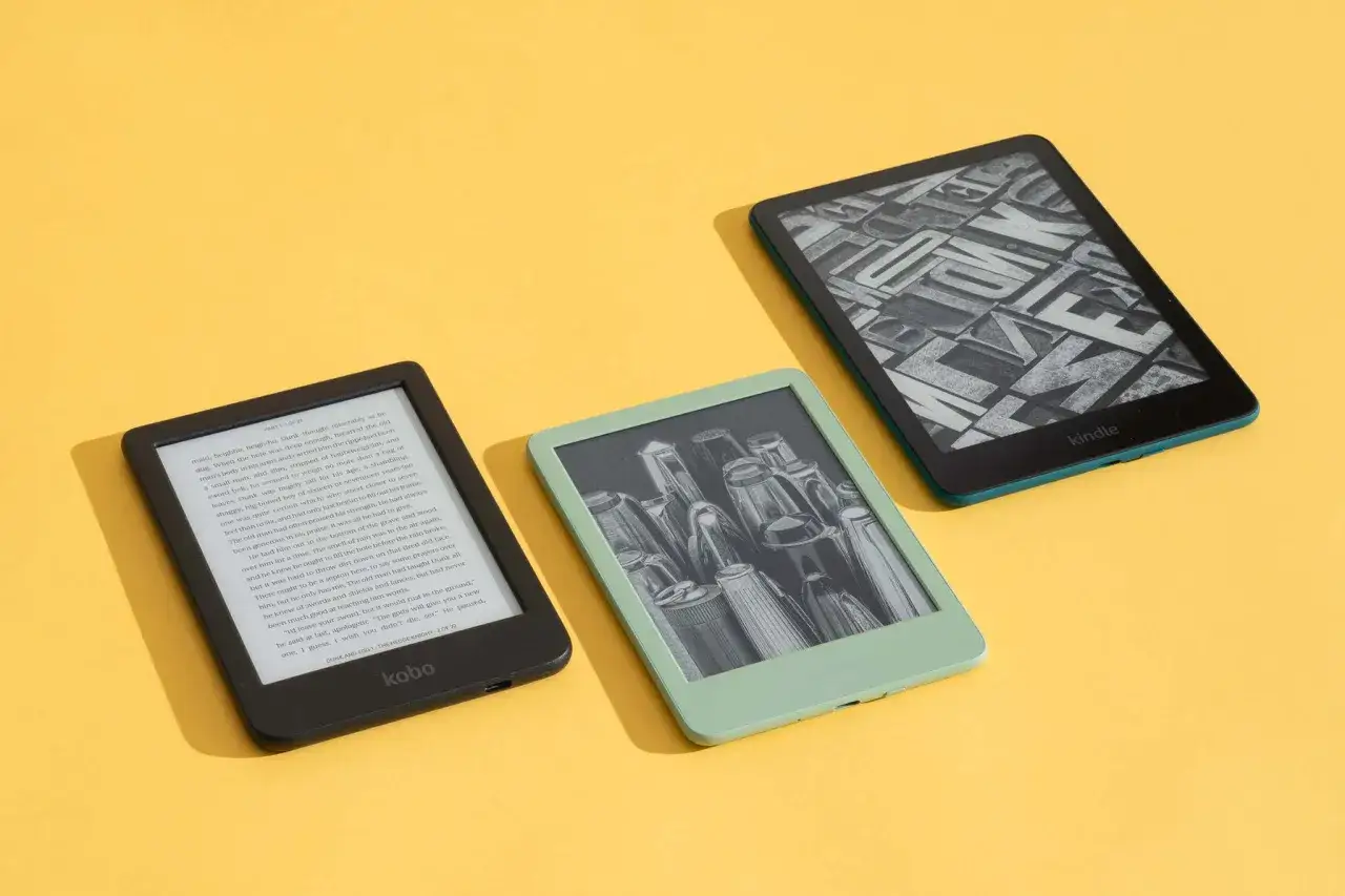 Trzy czytniki ebook na żółtym tle. Jeden czarny Kobo, jeden miętowy Kindle z grafiką, jeden zielony Kindle z tekstem. Idealne do czytania, sprawdź nasz czytnik ebook ranking.