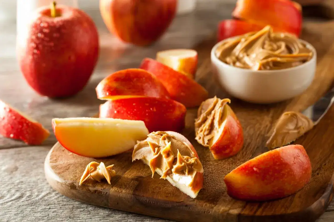 Des quartiers de pomme rouges et jaunes, certains tartin&eacute;s de beurre de cacahu&egrave;te, pr&ecirc;ts &agrave; &ecirc;tre d&eacute;gust&eacute;s. Parfait pour manger une pomme le soir.