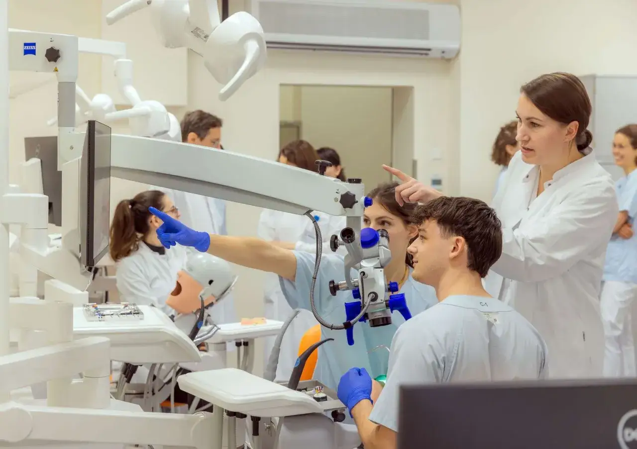 Studenten lernen im Labor, wo man Zahnmedizin studieren kann. Ein Mikroskop und ein Modellkopf sind zu sehen.